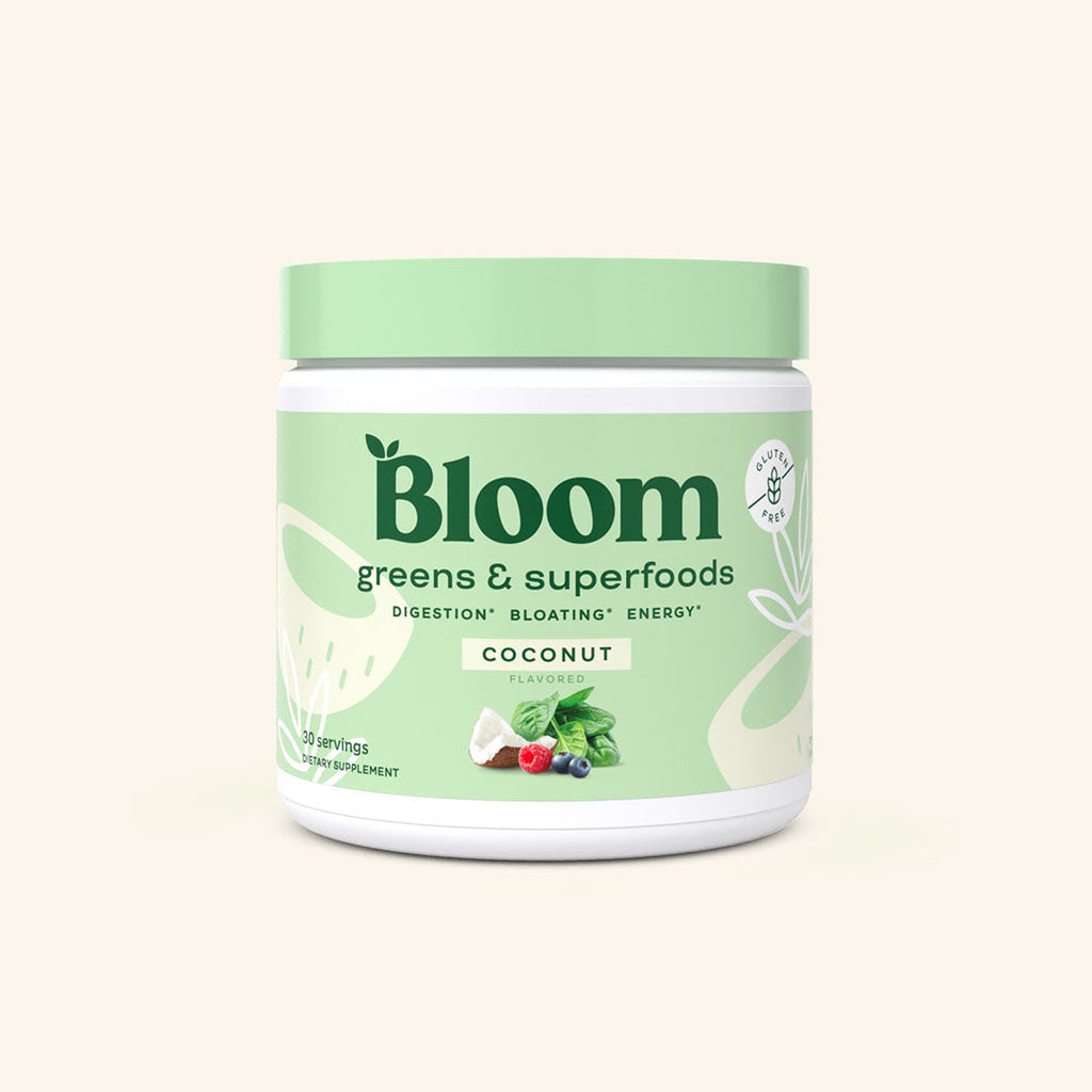 A container of Bloom greens & superfoods powder in Coconut flavor, labeled as supporting digestion, bloating, and energy. 30 scoop servings.